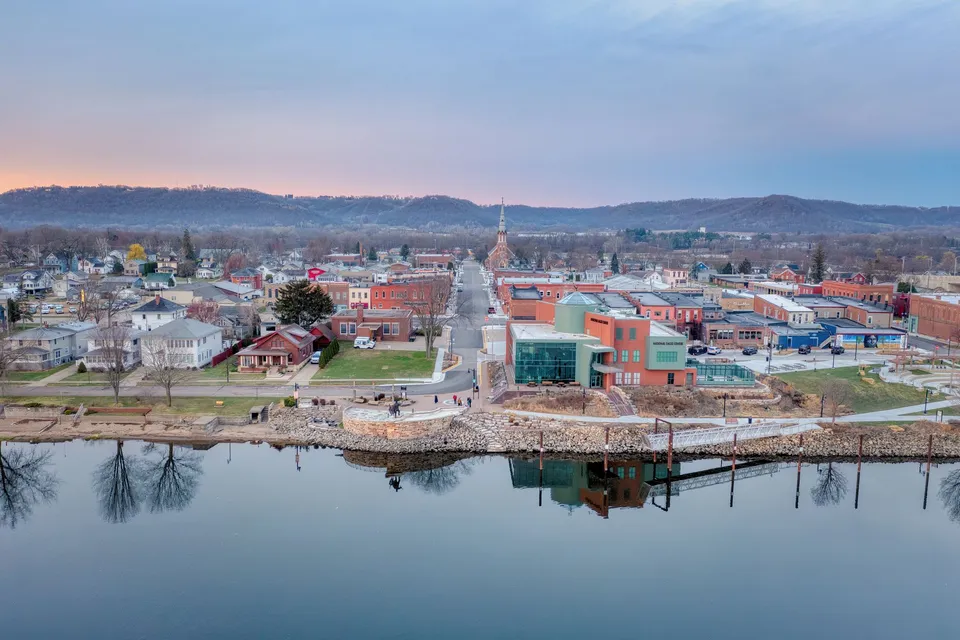 A scenic aerial view of Wabasha, Minnesota's downtown area with reflection on Mississippi River at dusk.