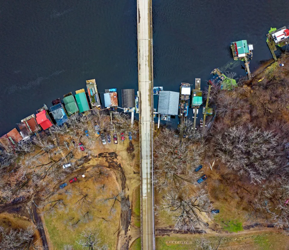 Drone shot capturing a bridge and colorful riverside houses in Winona, MN.